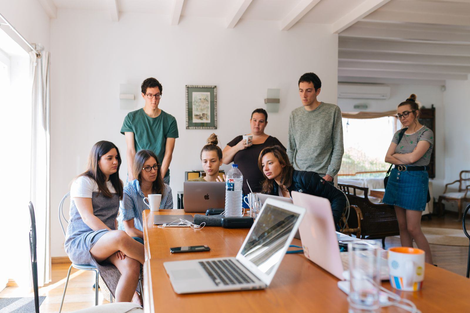 Group of friends gathered around a laptop