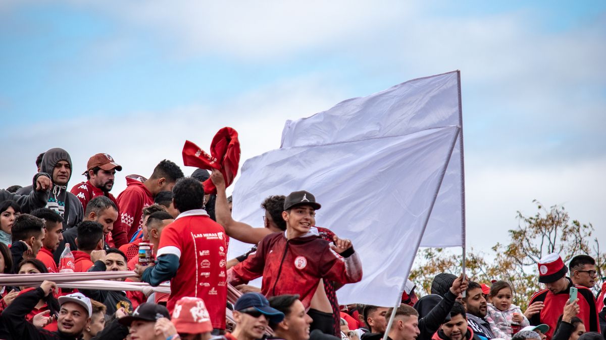 Football fans waving flags and scarves in the stands