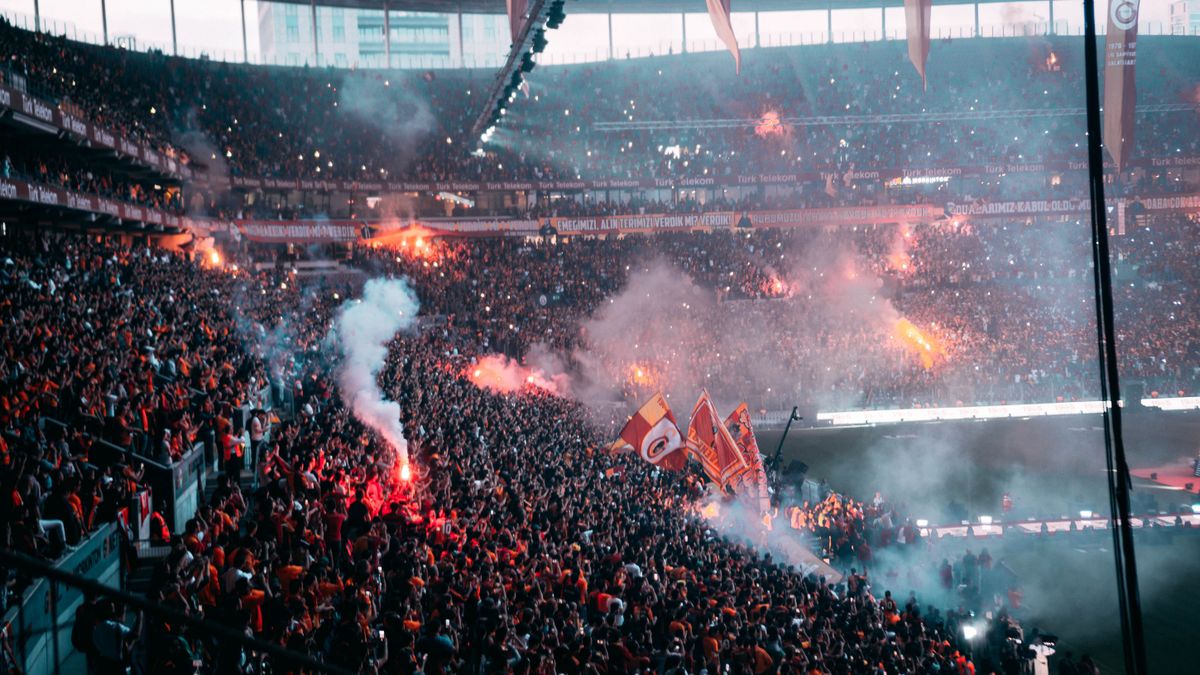 Fans and flares light up a stadium during a decisive World Cup match